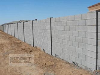 A concrete wall with a fence around it