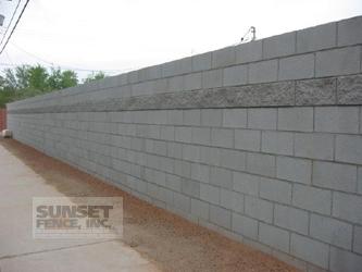 A concrete block wall with cement on the side.