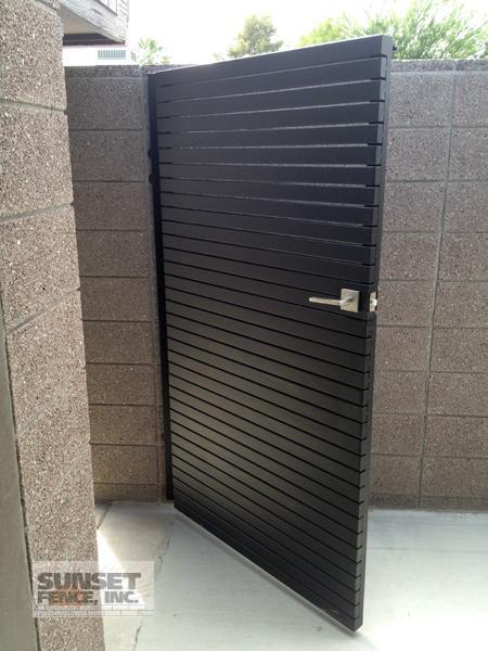 A black door in the corner of a bathroom.